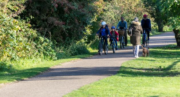 A family cycling through a country park