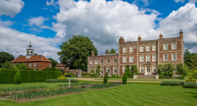 A historic house with grass in foreground and blue skies