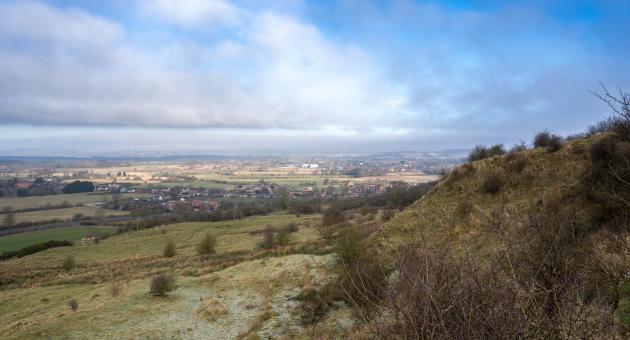 a landscape with hills in foreground and village in background