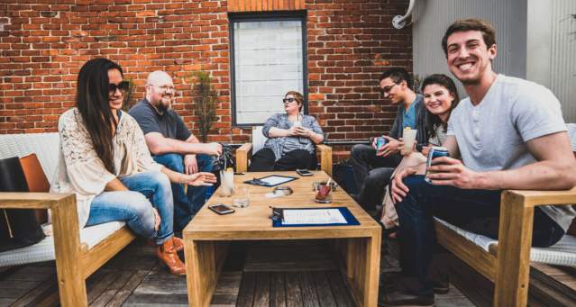 group of adults having cocktails at rooftop bar