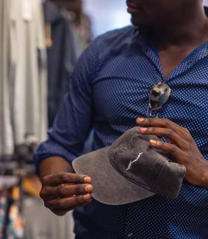 A man holding a hat with an outline of Lake George at Local