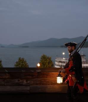 Soldier walking around Fort William Henry Museum with a lantern