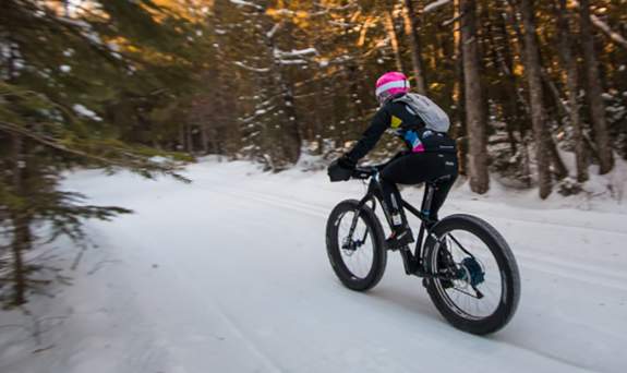 Fat Tire Biker going down trail in winter