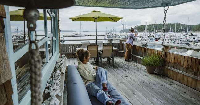 Two women enjoying the marina views from a covered patio.