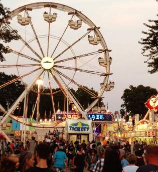 Crowd by food vendors and ferris wheel at the Monroe County Fair