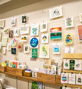 Display of wall art and prints at Gather Handmade Shoppe