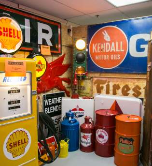 A booth full of vintage car signs and fuel pumps