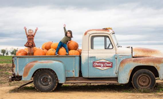children in back of vintage truck with pumpkins at Cherry Crest Adventure Farm