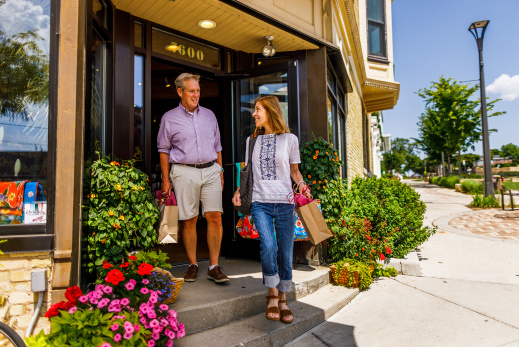 couple exiting shop with bags