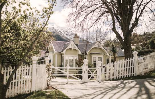 A historic white boutique hotel with snow topped mountain in the background