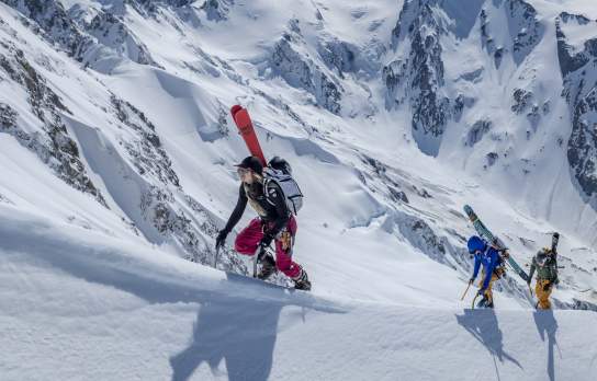 NZ Mountain Film & Festival 2025 hero image of three adventurers boot packing up a snowy ridgeline