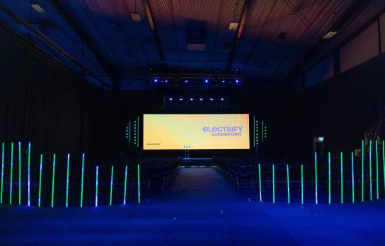 Stage, screen and light setup of an event in a dark exhibition centre