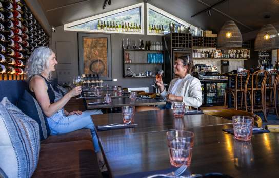 Two people enjoying a drop of wine at Fino Restaurant & Wine Bar at the Queenstown Marina in Frankton