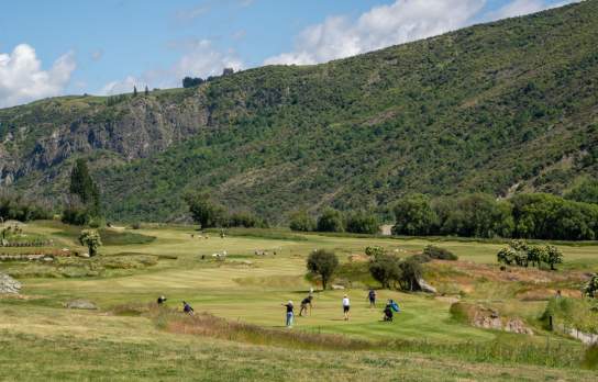 A landscape photo of golfers playing at the new Gibbston Valley Golf Course