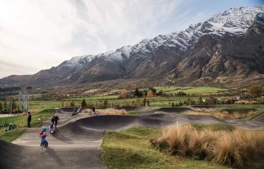 Kids enjoying the Hanley's Farm Pump Track with the Remarkables in the background