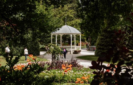 A couple walking the beautiful Queenstown Gardens loop with the verandah in the background