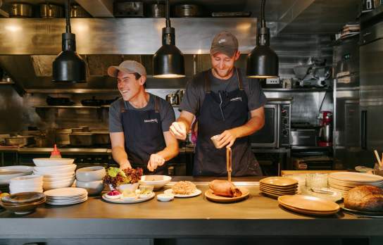 Staff dishing up plates at Muttonbird Restaurant in Wānaka