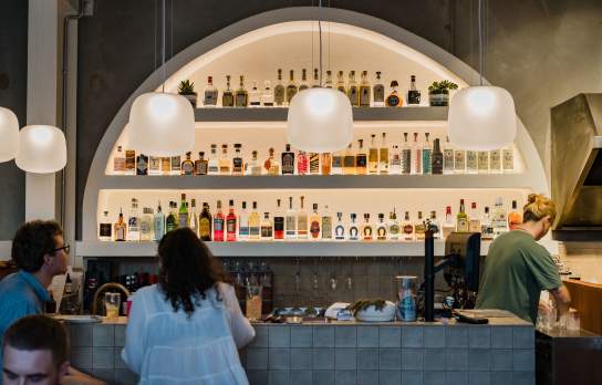 A couple enjoying a drink at the bar at Paloma Taqueria in Wānaka