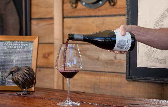 Hand pouring glass of Wet Jacket Pinot Noir
