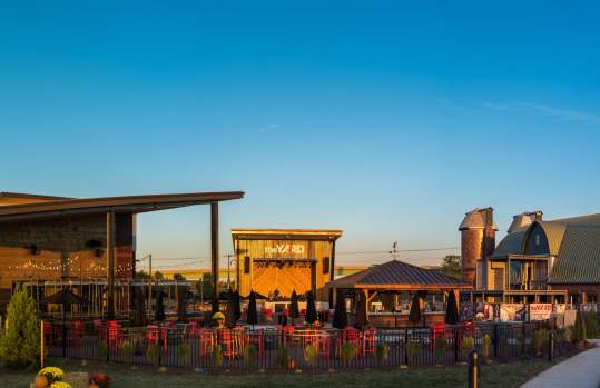 a pavilion, a stage and a barn with patio seating