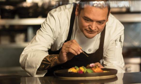 A chef meticulously plates a dish