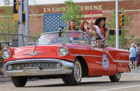 Three Miss Texas 66 Pinup Pageant contestants sitting on the back of a red classic car