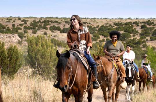 group of people horseback riding smiling