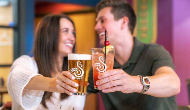 Couple doing cheers with beer at Isaac's Craft Kitchen & Brewery in Lemoyne