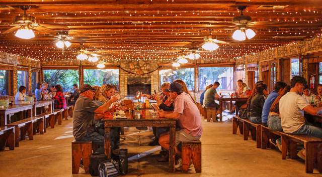 Photo of people sitting at long tables eating barbecue at Salt Lick Barbecue.