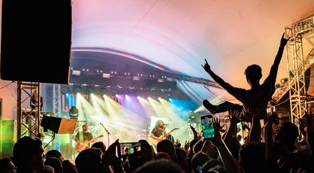 The silhouette of a crowd and someone crowd surfing during a concert at Stubb's.