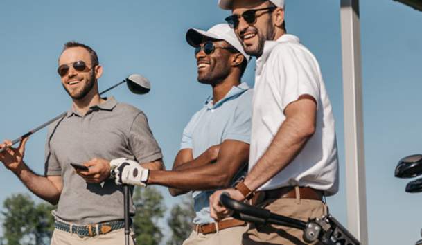 Guys laughing holding their golf clubs.
