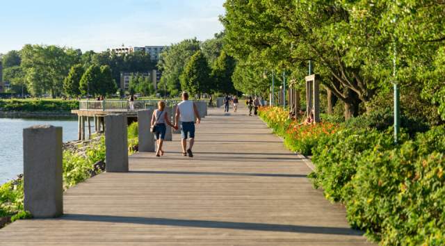 Couples enjoy a summer walk down the waterfront boardwalk in Burlington VT