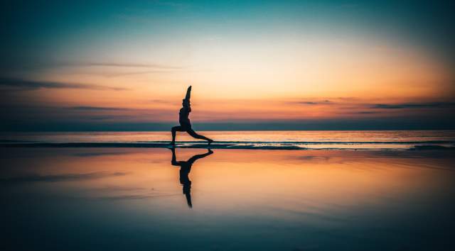 yoga at sunset on beach of Lake Champlain