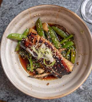 Plate of Fish with sugar snap peas and sauce at Franklin Ave Cocktails & Kitchen