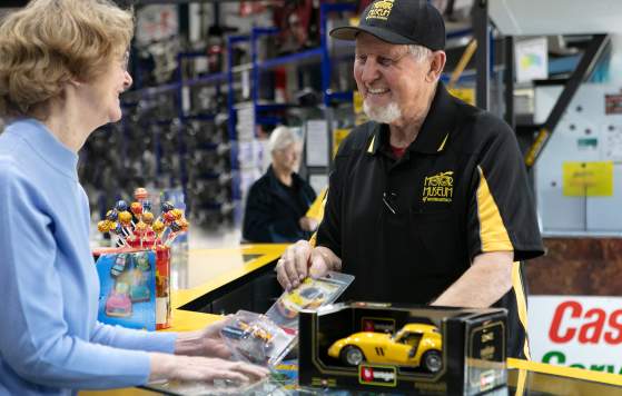 Motor Museum Worker Selling Toy Car