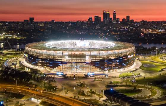 View of Optus Stadium with the Perth Skyline and sunset in the background.