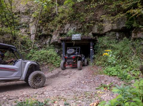 Two ATVs riding into a trailhead into the side of a mountain