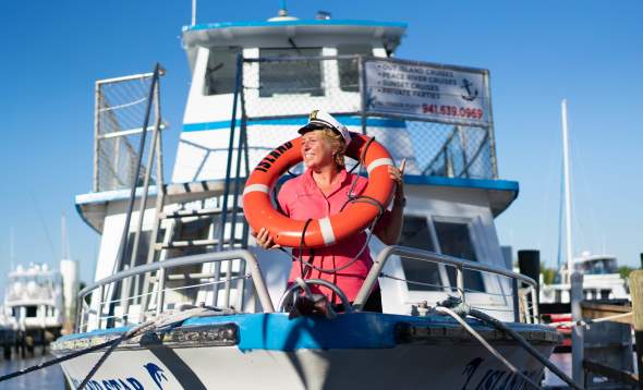 Brenda, a mate with King Fisher Fleet boat tours standing on a boat.