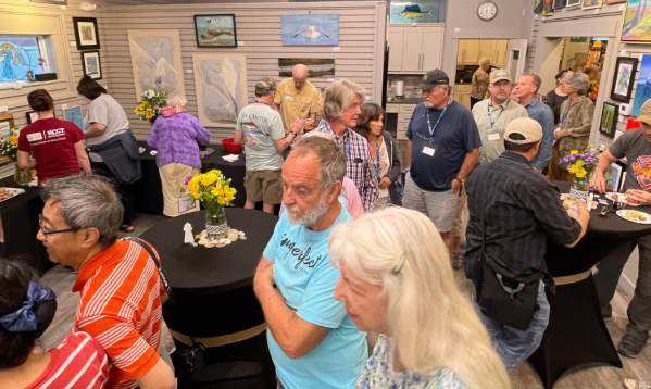 People enjoy viewing art and sampling snacks at a Port Aransas Art Center event