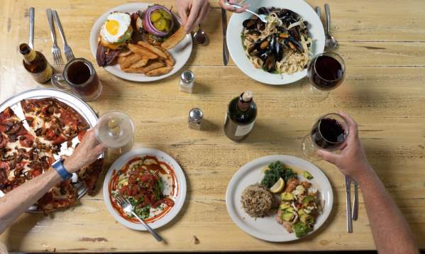 Overhead view of a table with people eating the food in the middle