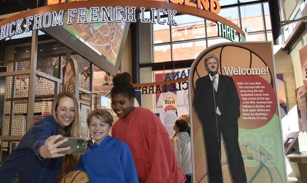 A selfie photo being taken with a boy and two girls at the Larry Bird Museum