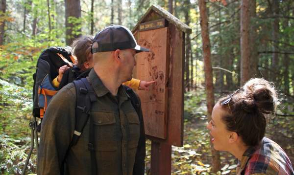 Family at trail marker, hiking