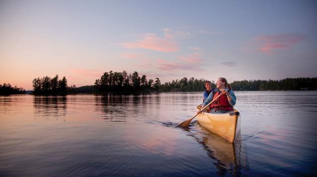 Two people canoeing on an inland lake