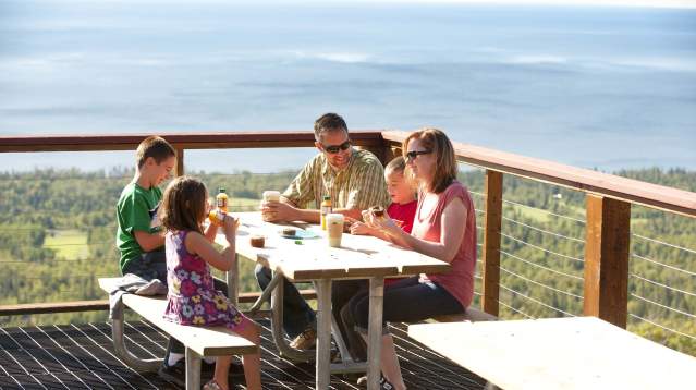 Family enjoying breakfast at outdoor picnic table