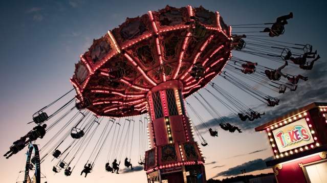 Swinging carousel with a sunset in the background and happy children laughing