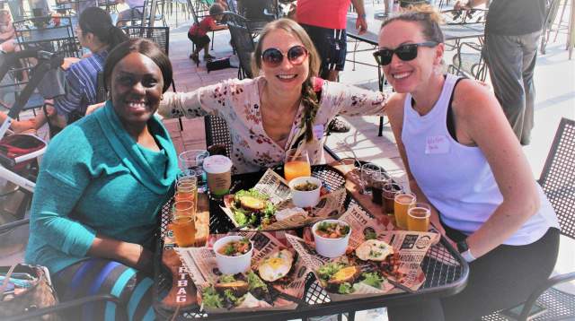 Three women enjoying lunch and drinks together on the outdoor patio at Dirtbag Ales in Cumberland County, North Carolina.