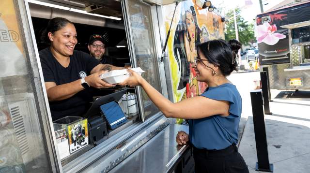 A young woman receives her food from a Fayetteville, NC food truck