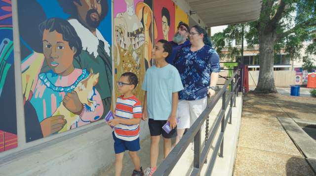 A family looks at the mural outside the Arts Council of Fayetteville in Cumberland County, NC