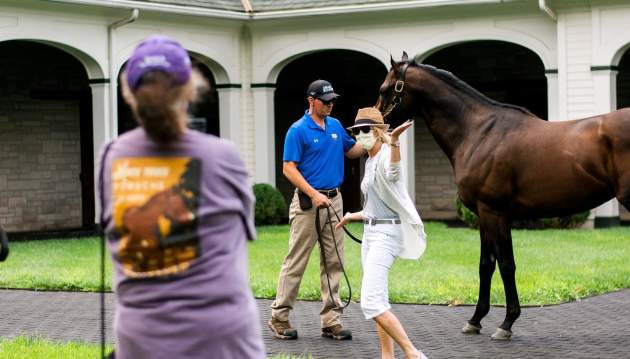 Woman posing with stallion at Spendthrift Farm