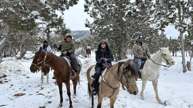 group of people on a winter trail horseback ride